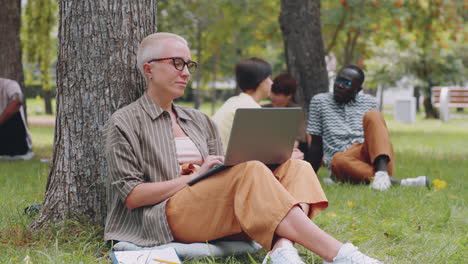 Portrait-of-Shorthaired-Caucasian-Woman-with-Laptop-in-Park